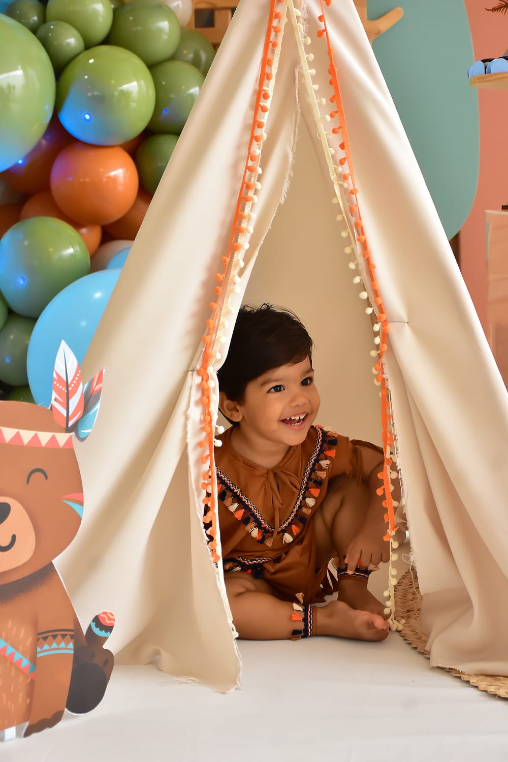 Criança sorrindo dentro de tenda em festa tema tribal