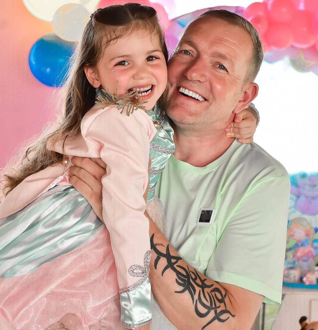 Pai abraçando a filha durante festa de aniversário